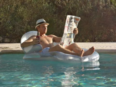 Нико Росберг в шляпе в бассейне с газетой перед гонкой в Спа
