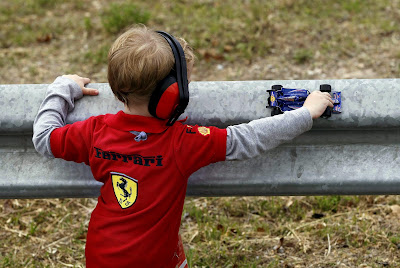 ребенок в футболке Ferrari с болидом Red Bull на Гран-при Испании 2013