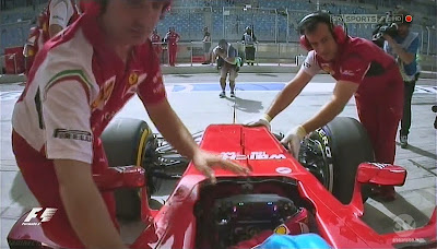 механики Ferrari закатывают болид Фернандо Алонсо в боксы во время первой сессии свободных заездов на Гран-при Бахрейна 2014