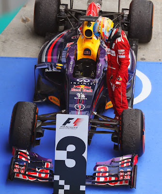 Фернандо Алонсо разглядывает болид Red Bull после финиша Гран-при Малайзии 2014