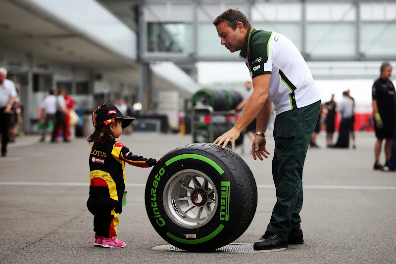 маленькая болельщица Lotus пробует на ощупь резину Pirelli на Гран-при Японии 2014