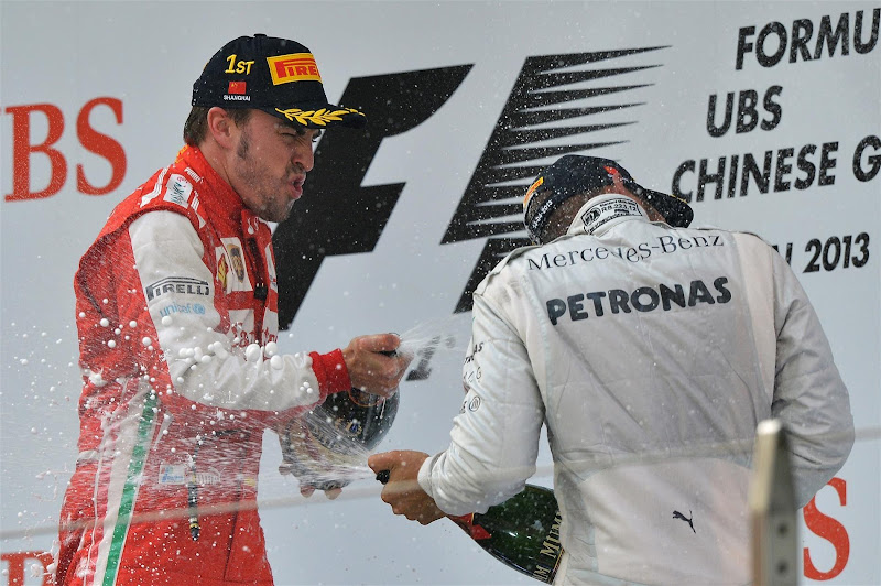Фернандо Алонсо и Льюис Хэмилтон разбрызгивают шампанское на подиуме Шанхая на Гран-при Китая 2013