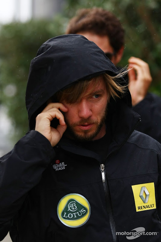 Ник Хайдфельд идет по паддоку в капюшоне и разговаривает по телефону на Гран-при Великобритании 2011