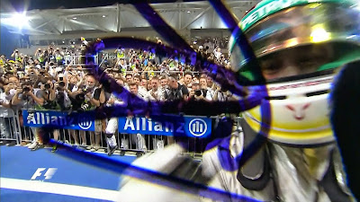 Льюис Хэмилтон ставит автограф на объективе телевизионной камеры на Гран-при Абу-Даби 2014