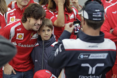 Рубенс Баррикелло фотографирует на телефон своего сына Эдуардо с Фернандо Алонсо на Гран-при Бразилии 2011