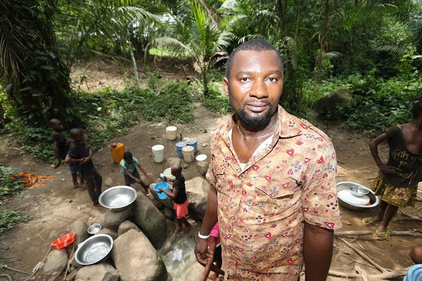 A youth leader who lives near one of Wilmar's Nigerian oil palm projects shows an alternative water hole the community has dug as a result of the plantation polluting its main water source. Photo courtesy of Environmental Rights Action-FoE Nigeria.