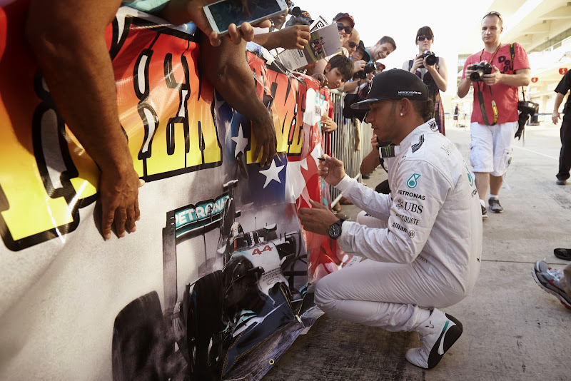 Льюис Хэмилтон ставит автограф на баннере болельщиков Гран-при США 2014