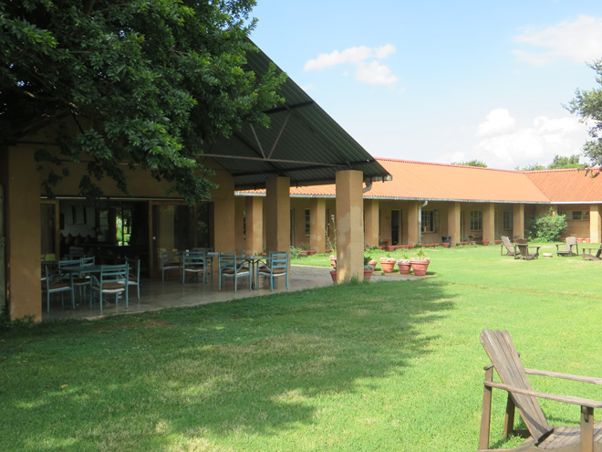 uitzicht op lounge, met daarachter een veranda met (dorm-)rooms bij Inkosana, noordelijke Drakensberg - Zuid Afrika