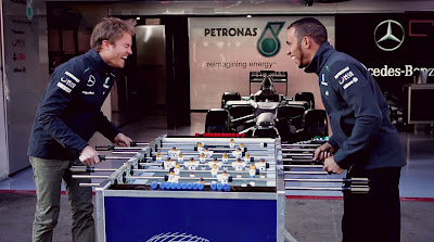 Нико Росберг и Льюис Хэмилтон играю в настольный футбол на съемках для Allianz перед Гран-при Австралии 2013