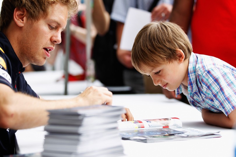 мальчик рассматривает автограф Себастьяна Феттеля на Гран-при Канады 2011
