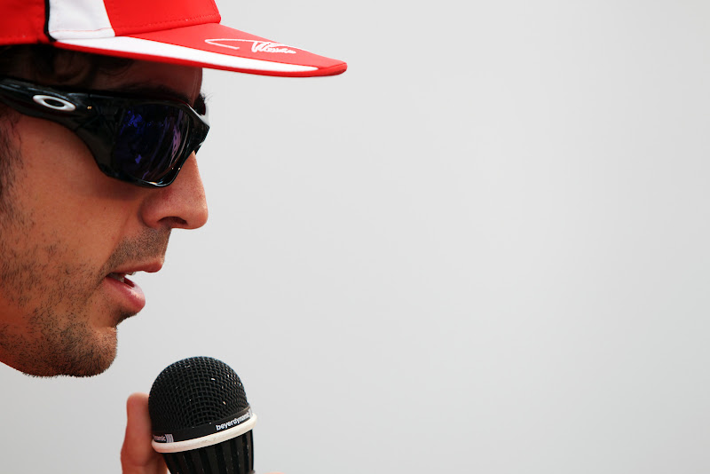 Фернандо Алонсо держит микрофон во время интервью на Гран-при Сингапура 2011