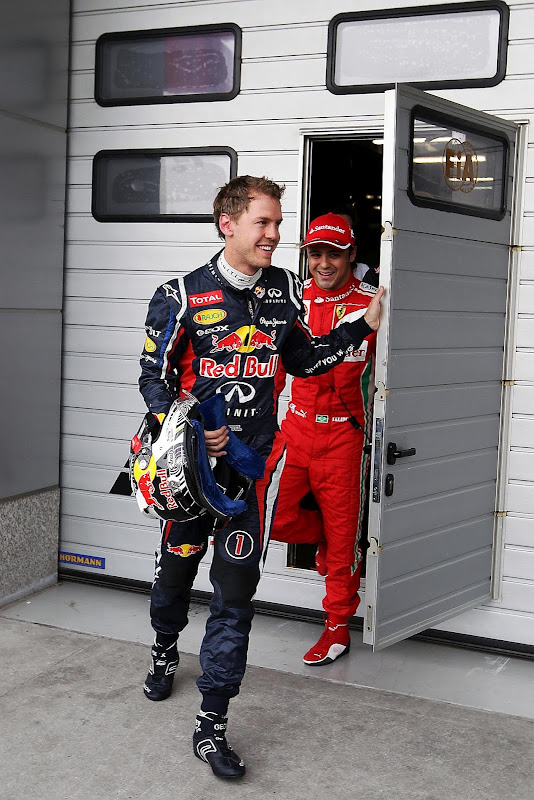 веселые Себастьян Феттель и Фелипе Масса покидают гараж FIA на Гран-при Китая 2012