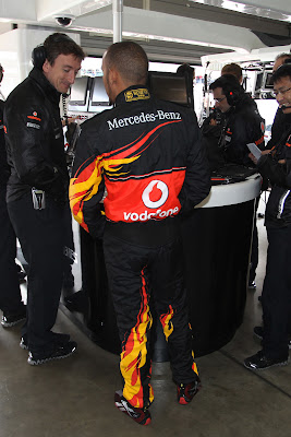 Льюис Хэмилтон с механиками McLaren в гараже команды во время квалификации в специально подготовленном для Гран-при Германии 2011 комбинезоне от Hugo Boss