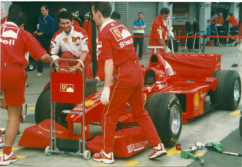механики Ferrari прячут крылья болида красными чехлами на Гран-при Великобритании 1998