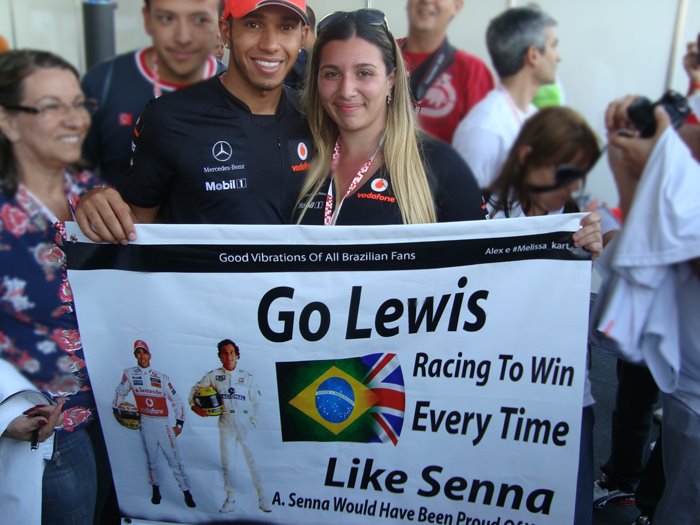 болельщица Melissa Kart фотографируется с Льюисом Хэмилтоном с баннером в поддержку пилота на Гран-при Бразилии 2011