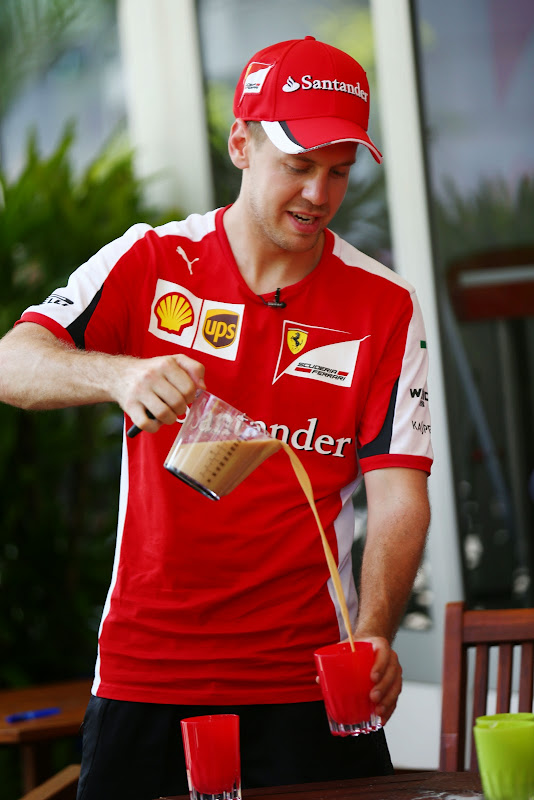 Себастьян Феттель наливает напиток на Гран-при Малайзии 2015