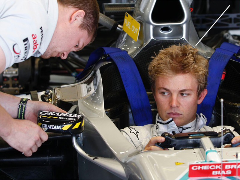 механик Mercedes GP поправляет зеркало болида для Нико Росберга