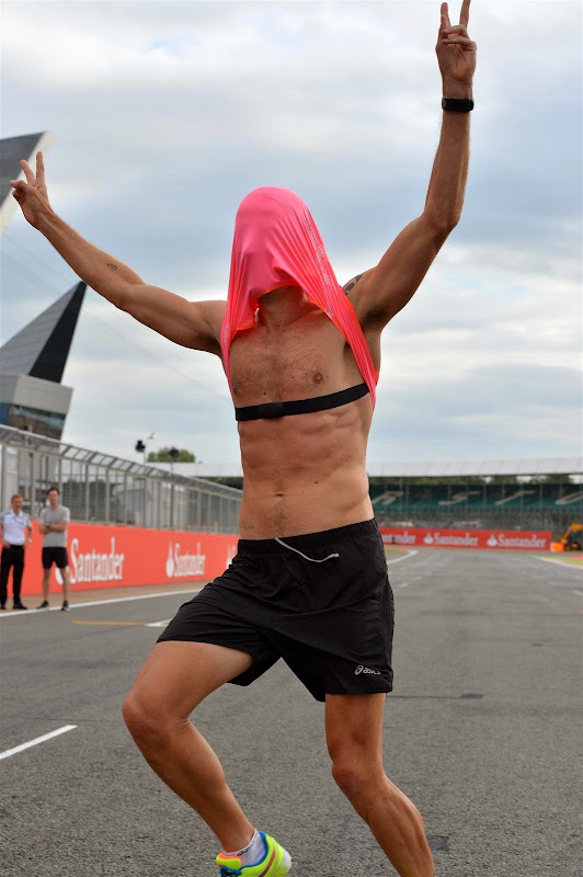 Дженсон Баттон в розовой футболке бежит по трассе Сильверстоуна на Гран-при Великобритании 2014