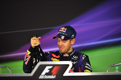 Себастьян Феттель достает бутылку шампанского на пресс-конференции после гонки на Гран-при Индии 2013
