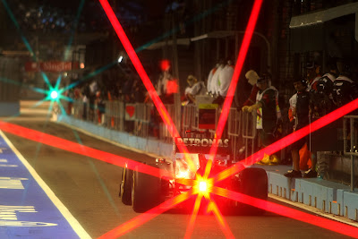 болид Mercedes GP едет по пит-лейну с красным огоньком позади на Гран-при Сингапура 2011