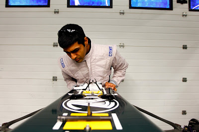 Карун Чандхок инспектирует переднее крыло Lotus T128 на предсезонных тестах 2011 в Хересе
