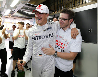 Михаэль Шумахер выпивает шампанское с механиком Mercedes на Гран-при Бразилии 2012
