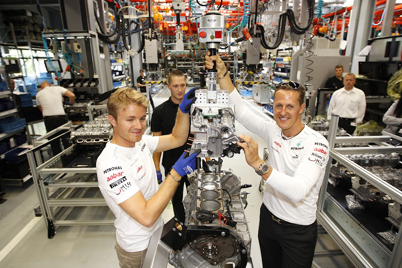 Нико Росберг и Михаэль Шумахер собирают двигатель Mercedes AMG перед Гран-при Германии 2012