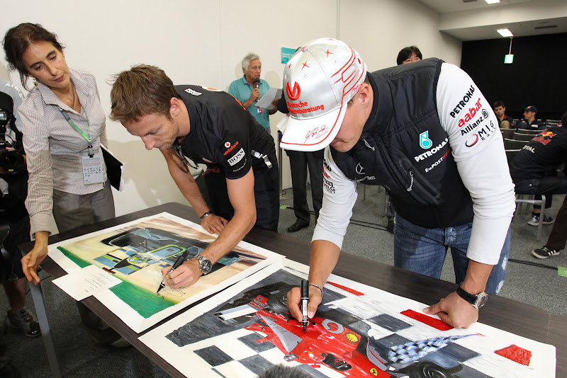 Дженсон Баттон и Михаэль Шумахер подписывают благотворительные постеры на Гран-при Японии 2011
