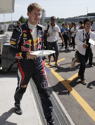 Себастьян Феттель с тарелкой на пит-лейне Сузуки на Гран-при Японии 2012