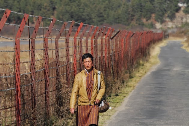 Local man walking past the tiny Bumthang airport of Bhutan