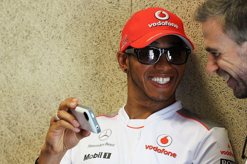 Льюис Хэмилтон показывает что-то смешное на своем телефоне инженеру на Гран-при Европы 2012