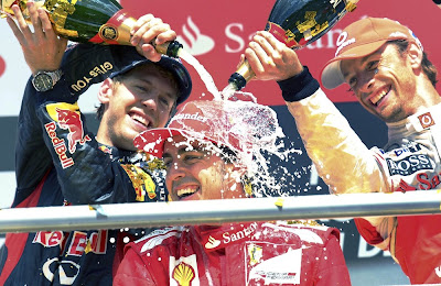 Фернандо Алонсо под душем шампанского от Себастьяна Феттеля и Дженсона Баттона на подиуме Гран-при Германии 2012