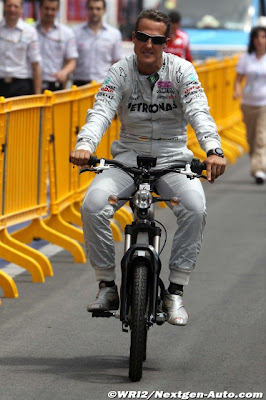 Михаэль Шумахер едет на мопеде на Гран-при Европы 2011 в Валенсии