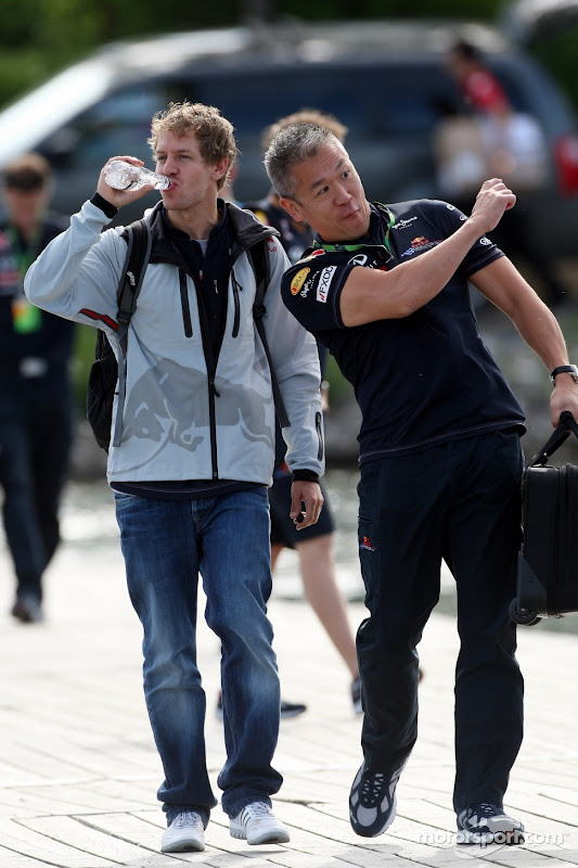 Себастьян Феттель идет с механиком и пьет воду на Гран-при Канады 2011