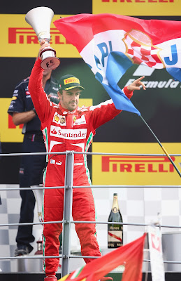 Фернандо Алонсо и большой флаг перед подиумом Монцы на Гран-при Италии 2013