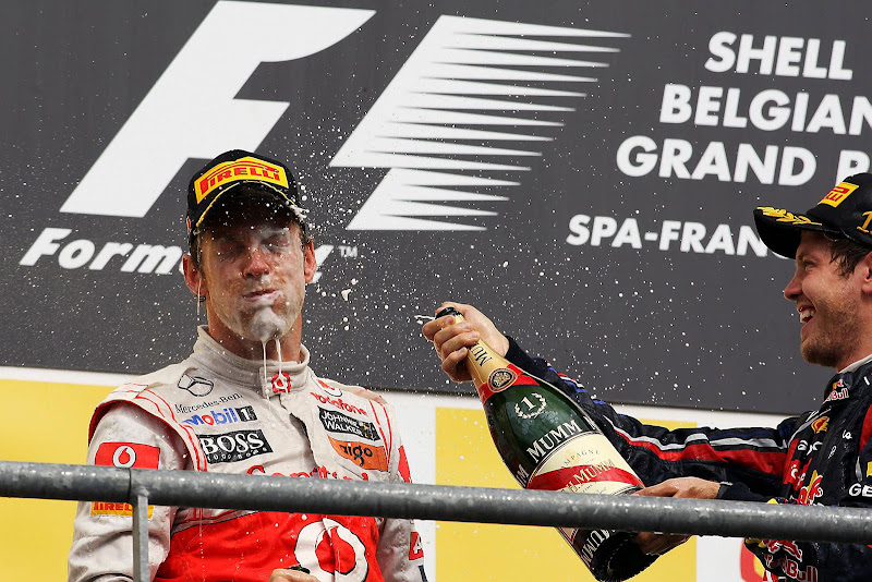 Себастьян Феттель брызгает шампанским в лицо Дженсону Баттону на подиуме Гран-при Бельгии 2011