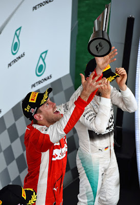 Себастьян Феттель подбрасывает победный кубок на подиуме Гран-при Малайзии 2015