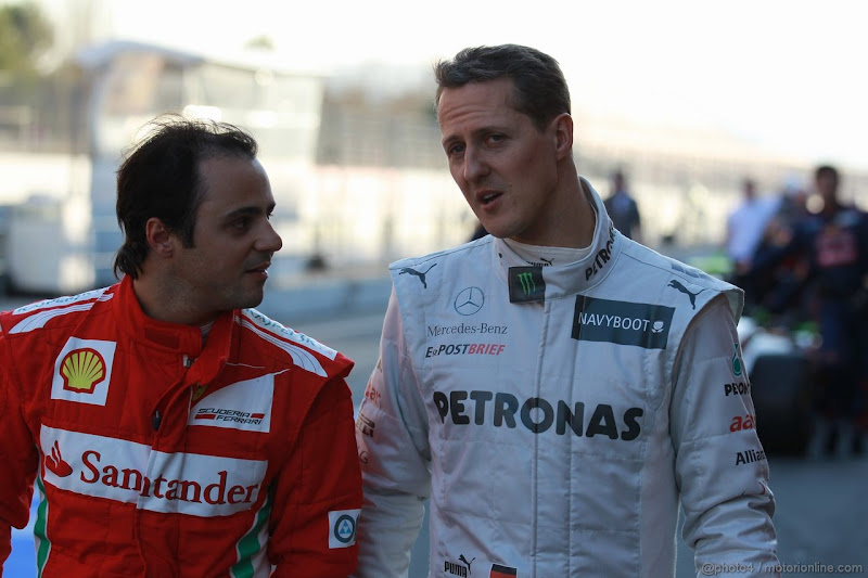 Фелипе Масса и Михаэль Шумахер разговаривают и идут по пит-лейну на предсезонных тестах 2012 в Барселоне 23 февраля 2012