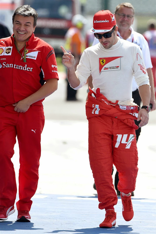 Фернандо Алонсо идет по паддоку и показывает палец на Гран-при Венгрии 2014