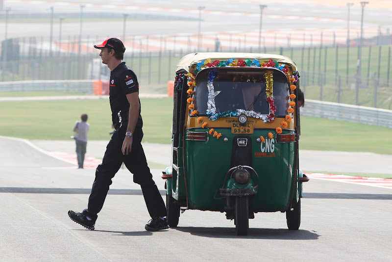 Дженсон Баттон уходит проч от индийской машинки на трассе Буддх на Гран-при Индии 2011