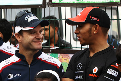 улыбающиеся Рубенс Баррикелло и Льюис Хэмилтон на Гран-при Индии 2011