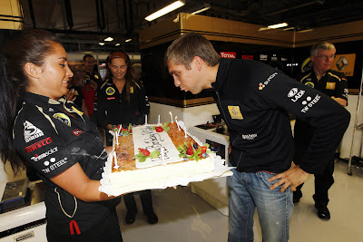 Виталий Петров в гараже Lotus Renault GP задувает свечи торта на Гран-при Италии 2011