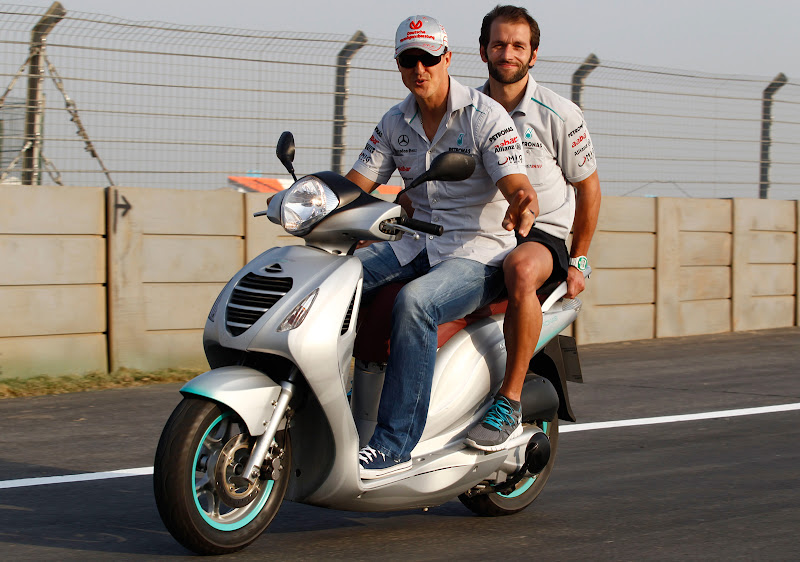 Михаэль Шумахер с механиком на мопеде на Гран-при Индии 2011