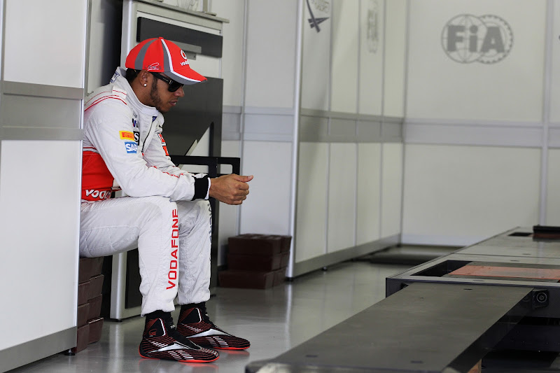 Льюис Хэмилтон сидит в гараже на Гран-при Бразилии 2012