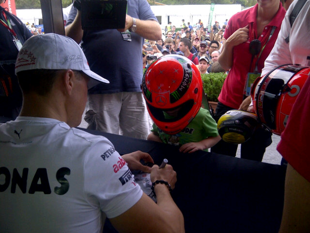 Михаэль Шумахер и ребенок в шлеме на автограф-сессии на Гран-при Австралии 2012