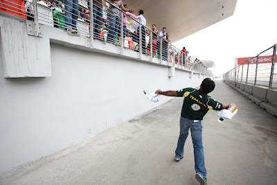 Карун Чандхок бросает кепки болельщикам на трибунах Гран-при Индии 2011