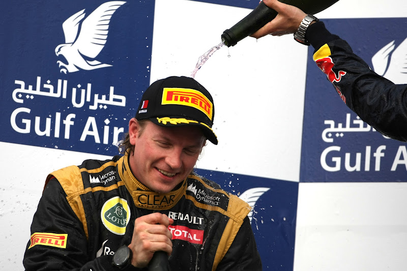 Себастьян Феттель льет шампанское на Кими Райкконена на подиуме Гран-при Бахрейна 2012