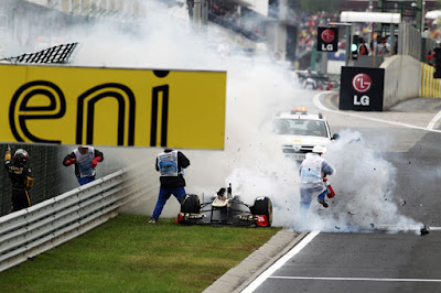маршалы тушат горящий Lotus Renault Ника Хайдфельда на обочине Хунгароринга на Гран-при Венгрии 2011