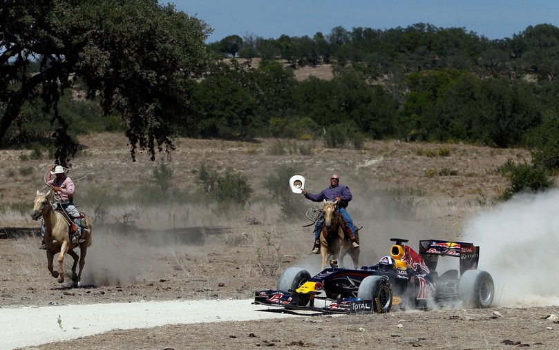 Дэвида Култхарда догоняют два ковбоя на показательных заездах Red Bull в Техасе 19 августа 2011
