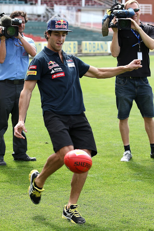 Даниэль Риккардо пинает мяч для регби перед Гран-при Австралии 2012